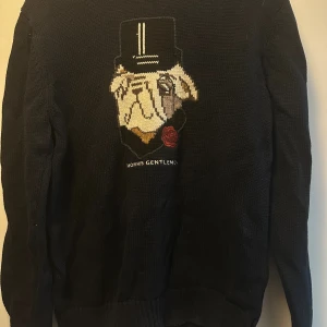 Svart stickad tröja Morris Gentlemen - Svart stickad tröja från Morris Gentlemen med broderad hund i hatt.