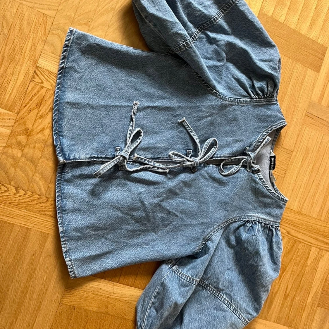Blå denimskjorta med puffärm och knyt