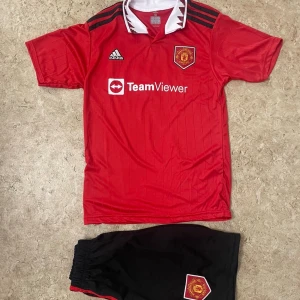 Manchester United Ronaldo 7 fotbollströja - Säljer en officiell Manchester United fotbollströja från Adidas med Ronaldo 7-tryck på ryggen. Tröjan är röd med svarta detaljer och vit krage, har klubbmärke och sponsortryck på bröstet. Materialet är lätt och andas, perfekt för träning eller match.