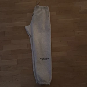 Grå Essentials mjukisbyxor - Säljer ett par riktigt najs essentials byxor. Strl L. Skick 10/10. Säljer eftersom de var för småa för mig.