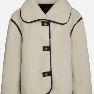 Edmund Teddy Jacket  - Säljer denna oversized teddyjacka från Neo Noir i färgen Ivory, supersnygg med svarta kontrastsömmar och stora knappar framtill. Jackan har bred krage och lång ärm, perfekt för dig som gillar en chill och trendig look. Materialet är mjukt och fluffigt, vilket gör den extra mysig. Säljer eftersom jag valde mellan denna och en annan. Originalpris 1.499 sek. Strl 38. Endast prövad en gång!!