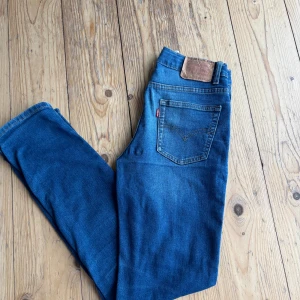 Levi's 502 Regular Taper jeans blå - Säljer ett par Levi's 502 Regular Taper jeans i klassisk blå tvätt. Modellen har fem fickor, knapp och dragkedja fram samt den ikoniska Levi's-lappen bak. Jeansen har en avsmalnande passform och är tillverkade i mjukt jeanstyg med snygga slitningar.