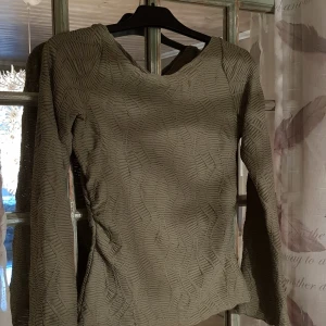 Ljusgrön långärmad topp Gina Tricot XS - Säljer en ljusgrön långärmad topp från Gina Tricot i storlek XS. Toppen har ett coolt strukturerat mönster med vågiga linjer som ger en unik look. Materialet känns lätt och stretchigt, perfekt för dig som gillar detaljer och vill sticka ut lite extra.