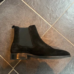 Svarta mocka chelsea boots - Snygga svarta chelsea boots i mocka från Zign. Knappt använda så dem är i bra skick! Storlek 43.