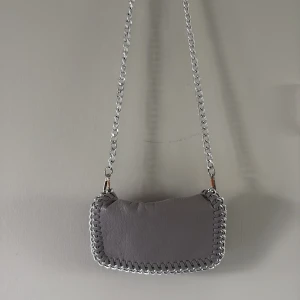 Tiamo väska - Handväska från tiamo i nyskick. Den enda ”defekten” är att färgen lossnat på spännena som man kan se på sista bilden. Varm grå färg mer åt det beiga hållet. Pris kan diskuteras!