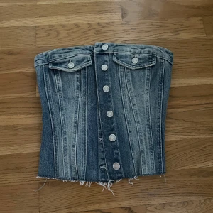 Denim korsett med knappar från zara  - Snygg denim korsett med knappar framtill och två fickdetaljer upptill. 