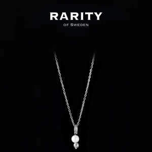Pearl Ring Necklace - Silver: Silverhalsband med pärla från Rarity - Stilrent halsband i silver från Rarity of Sweden med en tunn kedja och ett hänge med en vit pärla och en liten silverkula. Perfekt för dig som gillar minimalistisk och elegant design.