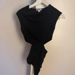 Svart body - Säljer denna bodyn. Toppen är ärmlös och har en stilren, modern look som passar perfekt till trendiga outfits. Materialet är mjukt och följsamt för en bekväm känsla.