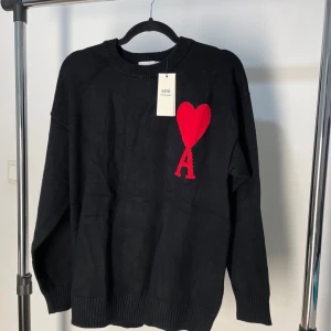 Svart stickad tröja från Ami - Svart stickad tröja från Ami. Tröjan är i nyskick och perfekt för dig som gillar unika plagg.