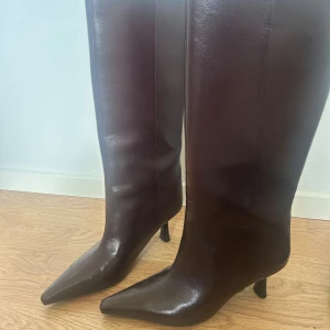 Bruna boots med klack och spetsig tå - Säljer ett par snygga höga boots i mörkbrunt skinn med spetsig tå och smal klack. Skit sköna att gå i och i princip helt nya då jag bara använt de 2 gånger. Köpta för 600 kr den 17e oktober. Mail bekräftelse finns! Säljer eftersom jag inte får användning av dom. 