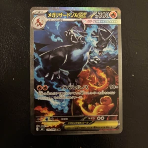 メガリザードンX ex - Cool japansk Pokémon-samlarbild med Mega Charizard X i en episk eldstrid! Perfekt för dig som älskar Pokémon, samlar kort eller vill ha något unikt att visa upp för vänner. Kortet har snygg design och passar både nya och erfarna samlare.