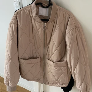 QUILTAD BOMBERJACKA STL S - Quiltad beige bomberjacka i storlek small säljes då den aldrig kommer till användning.