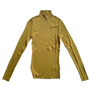 POLO TRÖJA - En tajt polotröja i guld/grön färg. 