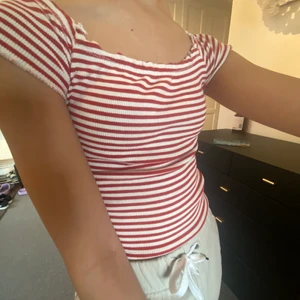 Jättesöt sommartopp - Jättefin liten söt topp från ginatricot. Stretchigt tyg så därför passar den XS-M. Den har resår i armar runt nacken och vid magen. Röd och vit randig.