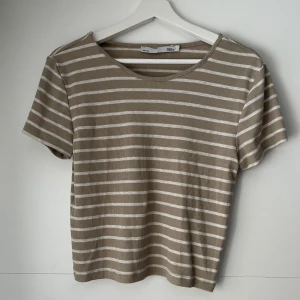 Beige/vit randig topp - Säljer en jätte fin beige/ vit randig topp. Lite kortare än en vanlig T-shirt i modellen. Använd ca 5ggr. Strl L❤️