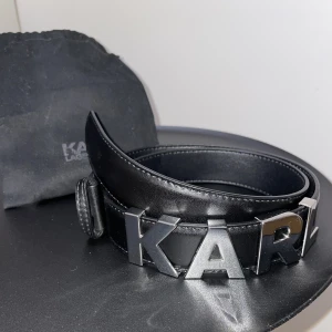 Karl Lagerfeld skärp - Svart Karl Lagerfeld skärp, 94 cm långt. Använd 1 gång, skicket är väldigt bra förutom att jag har gjort två egna hål som visas på sista bilden. Nypris 700kr