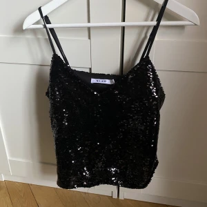 Glittrigt linne - Glittrigts svart linne med v-ringning från Nakd! Använt 1 gång så bra skick. Kommer inte ihåg vad linnet kostade i nypris tyvärr.