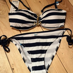 Bikini från New Yorker  - En mörkblå/vit randig bikini från New Yorker. Överdel storlek L, underdel storlek S