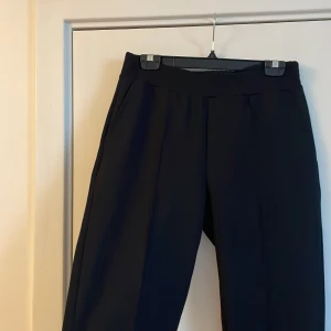 Svarta kostymbyxor gina - Svarta kostymbyxor från Gina. Veck på framsidan. Storlek L, frakt tillkommer