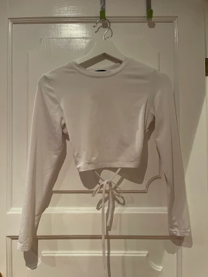 Vit långarmad topp med bar rygg - Vit långarmad topp med bar rygg, ganska kort. 