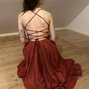 Balklänning röd - Jag är 170cm och strl S och den passar mig bra, har justerbara band som gör att den kan bli tightare och lösare vid magen/bysten. Aldrig använd pga corona, köpt för nypris 3500kr i Malmö. Lappar hänger kvar, även kvalitetskontroll utförd av Jadore.