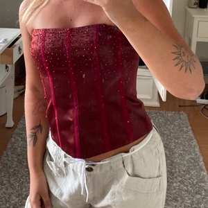 Korsett - Vinröd korsett med glitter, finns band till, dragkedja bak