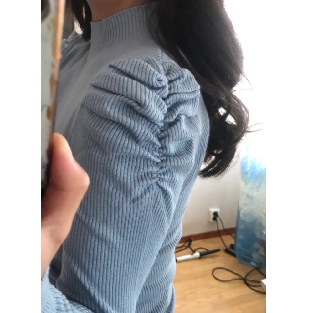 Ribbad mörkare pastellblå tröja, ganska lång ( jag är ungefär 163cm ), sitter relativt tajt med väldigt fin detalj av rynkning i axlarna. Inte tjock i materialet men kan vara ganska varm.. Tröjor & Koftor.
