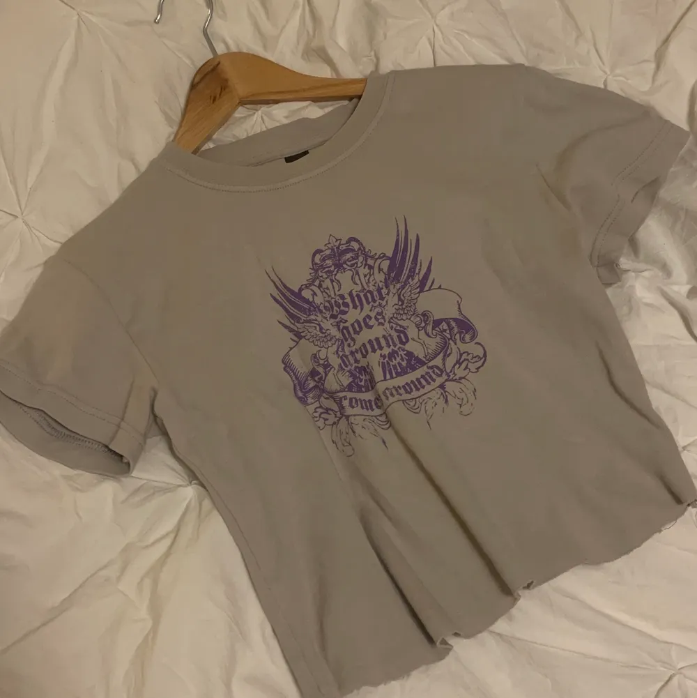 En croppad grå t-shirt med coolt lila tryck💜💜. T-shirts.