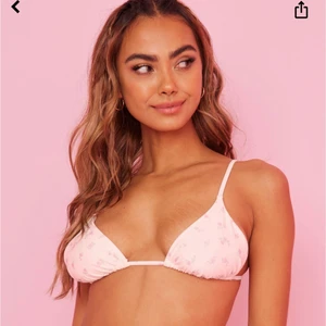 Bikiniöverdel från Bianca x Nelly  - Säljer denna superfina bikiniöverdel. Den är vit med blommor. Den är helt oanvänd med alla lappar kvar. Helt slut på hemsidan.   Köparen står för frakten.