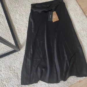 Satin kjol - Satin kjol i längre modell, aldrig använd/prislapp kvar. Resårband i midjan.