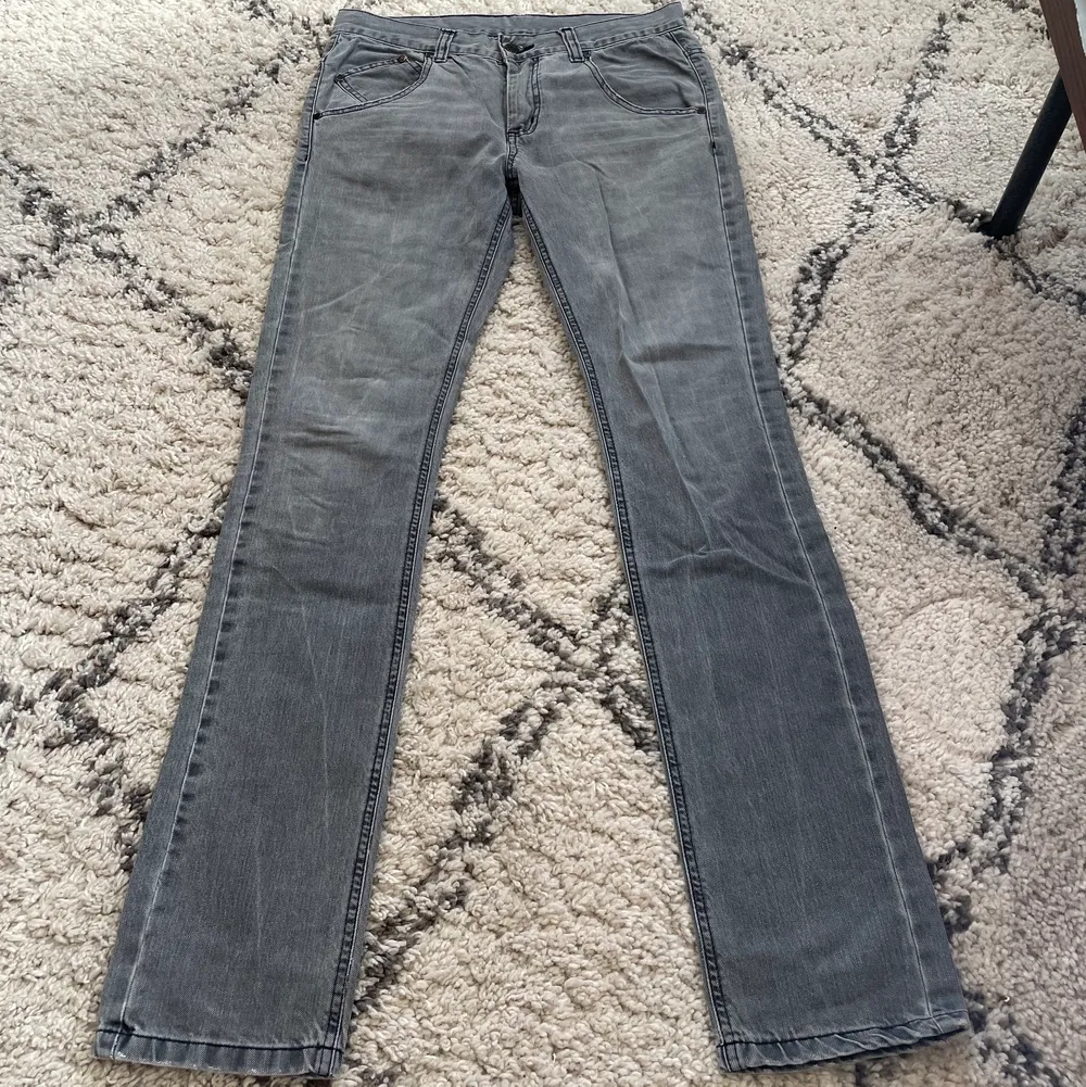 Gråa low waist jeans, straight slim fit. Innerbenslängd: 80cm, höftmått: 38,5cm rakt över. Bra skick med cool detalj på ena bakfickan. Jeans & Byxor.