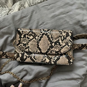 Väska o ormskinn - Liten väska i ormskinn med möjlighet att ha runt midjan, eller hålla med en guldig kedja, knappt använd