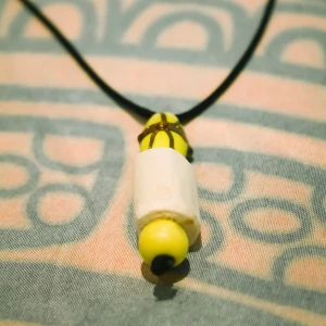 Halsband med trä och gula pärlor - Handgjort (av mig) halsband med ett hänge av glas/porslin och trä. Halsbandet har en klassisk låsmekanism i nacken. 💛