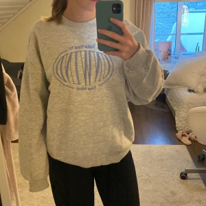 Sweatshirt  - Grå sweatshirt med ljusblått tryck på från Ginatricot. Storlek s, aldrig använd.