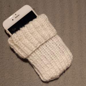 Ett värmande och skyddande fodral för mobilen - som förlänger batteritiden. Passar de flesta telefoner. Fodralet är 16×7,5 cm, men töjbart på bredden. Kan tvättas i 40 grader.