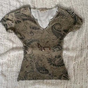Brun/grön tröja - Cool grön/brun t-shirt med paljettdetalj, storlek XXS! Sydd på insidan, antagligen gjord tightare men den var i det skicket när jag köpte den!