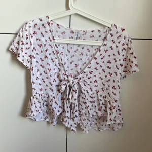 Blommig topp - Jättefin blommig topp med knytning fram Aldrig använd, storlek S men passar även XS Frakt tillkommer