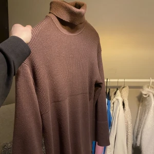 Klänning - En brun fin stickad klänning från bikbok i storlek XS, använd fåtal gånger. Går under knäna och är 168. Den har en slits på sidorna och vida armar. 🤎