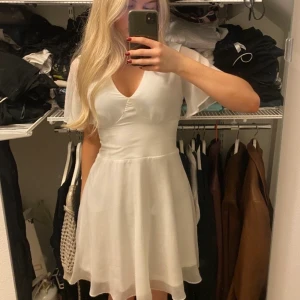 Vit kort klänning - ättefin skolavslutning/student klänning. Jättefin passform! Ordinarie pris 549, använd endast en gång på skolavslutning vilket är varför jag säljer den. Jag är 160 cm lång och på mig slutar den ovanför knäna. Köparen står för frakt!