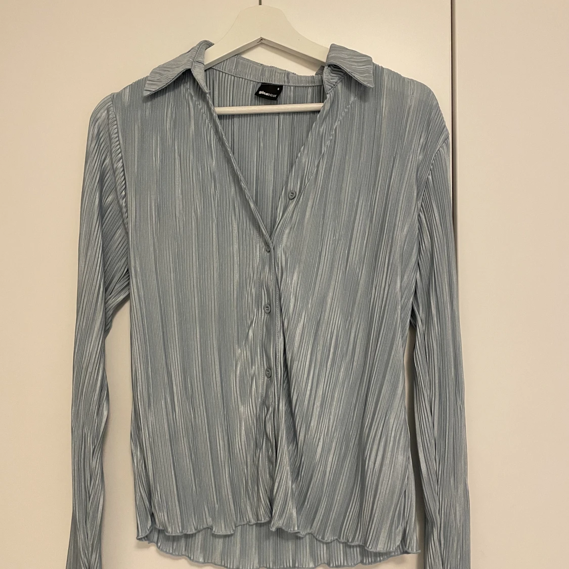 Blå glansig blusskjorta