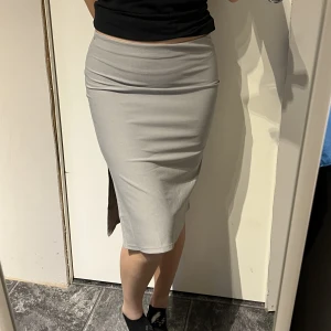 Kjol - Grå/silvrig knälång kjol. Väldigt fint skick då den knappt är använd. 