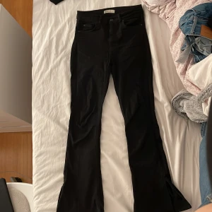 Jeans  - Svarta jeans med en slits på yttersidan, utsvängda i storleken S