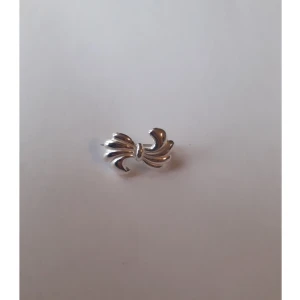 Silverbrosch - Brosch i äkta silver. Formad som en rosett med knäppe baktill   Ask: 10 kr (valfritt) Frakt: 15 kr