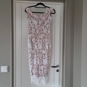 Festklänning  - Festklänning i vit spets med nude undertyg. Endast använd vid ett tillfälle