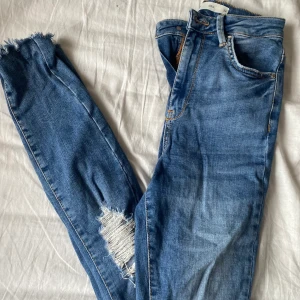 Håliga Skinny jeans från Gina Tricot  - Fina jeans med hål från Gina Tricot, storlek 34. Knappt använda, öpprivet vid fötterna som är en riktigt snygg dittalj tycker jag. Köparen står för frakten, priset kan diskuteras 💕Hör gärna av dig för mer information eller om du är intresserad!🤩