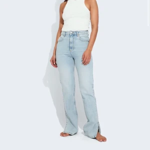 Blåa jeans med slit - Säljer dessa blåa oandvända jeansen från never Denim i storlek 26/32. Dom är högmidjade med slit på sidan. Nypris ligger på 600 så säljer dom därför för 200kr