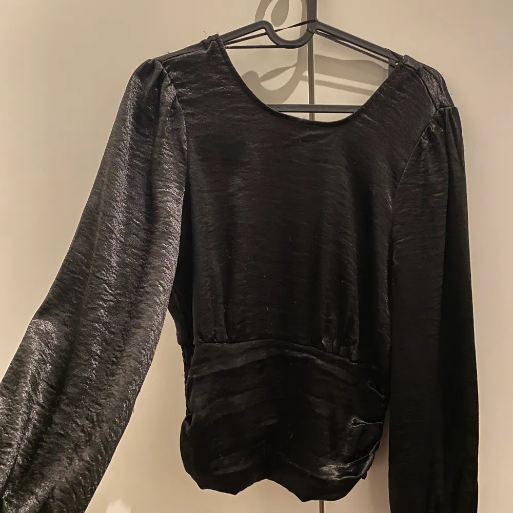 Säljer en svart blus/topp som passar perfekt till fest eller finare tillställningar. Använd 1-2 gånger så nyskick. Materialet liknar satin. Lite djupare urringning i ryggen.  Storlek S.  Möts upp eller fraktar 💘. Blusar.