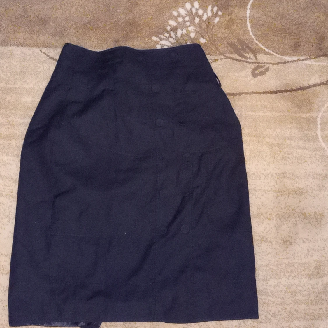black short skirt with buttons in line at the front of the skirt. - 90