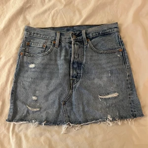 Levis kjol - Kort kjol från levis säljes då den inte passar längre. Storlek 27 motsvarar ungefär S/liten M. Fina slitningar och i bra skick Köparen står för frakten💞