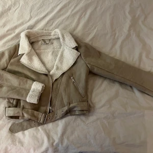 Beige jacka från nelly - Beige jacka med teddymaterial invändigt och mochamaterial utvändigt säljes då den inte kommer till användning. Den är ganska tunn och är i bra skick, skulle säga att den är normal i storleken. Köparen står för frakten💞